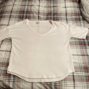 A white short sleeved top with a V-neck. Has a soft ribbed texture